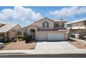 Inviting two-story home featuring a two-car garage, arched entry, and traditional desert landscape at 9785 Turtle Head Ct, Las Vegas, NV 89117