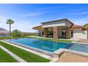 Modern pool and spa alongside a stone-clad home, with an outdoor seating area and stunning mountain views at 1 Costa Del Sol Ct, Henderson, NV 89011