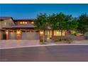 Charming home exterior featuring a three-car garage, brick accents, and a well-manicured front yard at 10433 Ember Rose Ave, Las Vegas, NV 89135