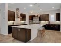 Modern kitchen with dark wood cabinets, stainless steel appliances, and a large center island at 10433 Ember Rose Ave, Las Vegas, NV 89135