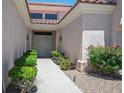 Welcoming front entrance with a secure gate, mature landscaping, and a paved walkway leading to the door at 10720 Bennington Ct, Las Vegas, NV 89134