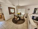 Bright dining area with a round glass table, chandelier, and access to the living area at 10968 Geyser Peak St, Henderson, NV 89052