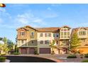 Charming townhome featuring stone accents, multiple garage doors, and well-maintained landscaping at 11 Via Vita Bella, Henderson, NV 89011