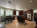 Spacious kitchen featuring wood cabinets, a kitchen island with barstool seating, and tile flooring at 11457 Steponia Bay St, Las Vegas, NV 89141