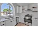 Upgraded kitchen featuring stainless steel appliances, marble countertops, and open shelving at 1638 Candice St, Las Vegas, NV 89156