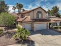 This two-story home boasts a tile roof, desert landscaping, and a spacious two-car garage at 1721 Mill Canyon Dr, Las Vegas, NV 89128