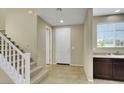 Bright home entryway with tiled floor, staircase, and convenient sink area at 1976 Galleria Spada St, Henderson, NV 89044