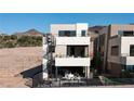 Modern three-story home featuring a rooftop deck with spiral staircase, sleek design, outdoor living spaces, and scenic mountain views at 20 Lakefront Dr, Henderson, NV 89011
