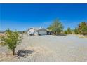 Inviting single-story home with gravel landscaping and mature trees on a spacious lot at 2251 Bridger St, Pahrump, NV 89048
