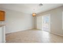 A well-lit dining room with tile flooring, a modern chandelier, and sliding glass doors to the outdoor area at 3405 Kingbird Dr, North Las Vegas, NV 89084