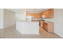 Open kitchen featuring wooden cabinetry, modern appliances, and tile flooring, perfect for cooking and entertaining at 3405 Kingbird Dr, North Las Vegas, NV 89084