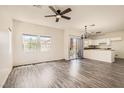 Open-concept living area boasts new wood flooring and a modern chandelier and ceiling fan at 3820 Wiggins Bay St # 201, Las Vegas, NV 89129