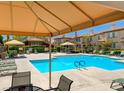 A shared pool is surrounded by lounge chairs and shaded seating areas at 3820 Wiggins Bay St # 201, Las Vegas, NV 89129