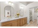 Bathroom with double vanity, modern fixtures, wood cabinets, stone countertop, and walk-in closet at 5157 Future Dr, Las Vegas, NV 89130