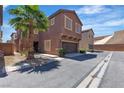 Two-story townhome featuring stucco siding, attached garage, and a well-manicured front yard at 715 Taliput Palm Pl, Henderson, NV 89011