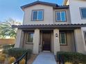 Charming home exterior featuring a covered entrance, dark door, and manicured landscaping at 7332 N Decatur Blvd # 2, North Las Vegas, NV 89084