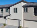 Exterior view showcasing attached two-car garages with modern doors and updated architectural details at 7332 N Decatur Blvd # 2, North Las Vegas, NV 89084