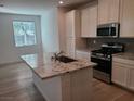 Bright kitchen featuring a large island with granite countertop, stainless steel appliances, and ample storage at 7332 N Decatur Blvd # 2, North Las Vegas, NV 89084