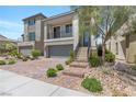 Two-story home with a two-car garage, balcony, landscaped front yard, and inviting stone walkway leading to the front door at 7977 Texas Hills St, Las Vegas, NV 89113