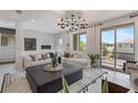 Cozy living area with a plush sofa, stylish rug, plants, and natural light streaming through the large glass doors at 7977 Texas Hills St, Las Vegas, NV 89113