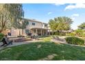 Spacious backyard featuring a covered patio, fire pit, lounge chairs, and lush green lawn at 8121 Eagle Clan Ct, Las Vegas, NV 89131