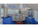 Bright living room with soaring ceilings, large windows, and comfortable seating, blue carpet at 8196 Horseshoe Bend Ln, Las Vegas, NV 89113