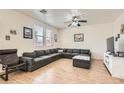 Spacious living room with a large sectional sofa, ceiling fan, and wood-look floors at 8252 Pearl Oasis Ct, Las Vegas, NV 89139