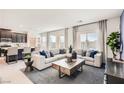 Spacious living room with large sectional sofa, stylish decor, and adjacent kitchen at 9588 Archer Peak Ct, Las Vegas, NV 89143