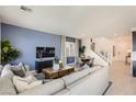 Open-concept living room with blue accent wall, modern furniture, and staircase access at 9588 Archer Peak Ct, Las Vegas, NV 89143