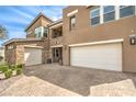 Exterior elevation showing the brick paver driveway and three car garage on a sunny day at 9655 Skye Star Ave, Las Vegas, NV 89166
