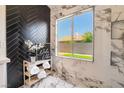 Elegant bathroom showcasing marble walls, a large window, and a modern design at 9705 Standard Ave, Las Vegas, NV 89129