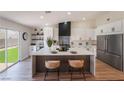 Modern kitchen with white cabinets, stainless steel appliances, and a large island with seating at 9705 Standard Ave, Las Vegas, NV 89129
