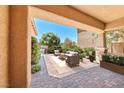 Covered outdoor patio with comfortable seating and a view of the landscaped yard at 1134 Pandora Canyon St, Henderson, NV 89052