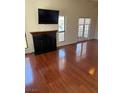 Bright living area with fireplace, TV, and wood floors with access to the outside via glass paneled double doors at 2212 Sunfish Dr # D, Henderson, NV 89014