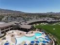 Resort-style pool area with blue umbrellas and tables, adjacent to a lush green lawn at 2537 Terrytown Ave, Henderson, NV 89052