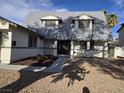 Welcoming two-story home with a decorative front door, manicured landscaping, and a stone pathway at 3056 Garnet Ct, Las Vegas, NV 89121