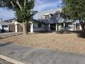 Inviting two-story home featuring a charming front yard with mature trees and low-water landscaping at 3056 Garnet Ct, Las Vegas, NV 89121