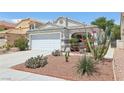 Exterior shot of home showcasing desert landscaping, a two-car garage, and neutral paint scheme at 371 Legacy Dr, Henderson, NV 89014
