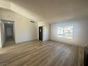 Bright living room features new wood-look flooring and a large window for ample natural light at 3920 Aspencrest Dr, Las Vegas, NV 89108