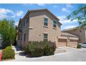 Exterior of a two-story home with a two-car garage, desert landscaping, and stucco facade at 4610 Lime Straight Dr, Las Vegas, NV 89115