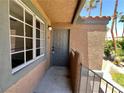 Cozy entryway with a gray door and textured stucco walls under a covered balcony at 5260 Mission Monterey Ln # 208, Las Vegas, NV 89107