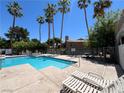 Community pool with lounge chairs, palm trees, and well-maintained grounds at 5260 Mission Monterey Ln # 208, Las Vegas, NV 89107