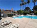 Inviting community pool with lounge chairs and palm trees, perfect for relaxation at 5260 Mission Monterey Ln # 208, Las Vegas, NV 89107