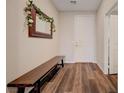 Inviting entryway with wood-look floors, a wooden bench, and a decorative mirror at 5299 Silver Branch Ave, Las Vegas, NV 89118