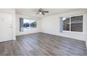 Bright living room showcasing updated flooring, large windows, and a ceiling fan at 5535 Oxbow St, Las Vegas, NV 89119