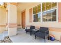 Inviting front porch with comfortable seating, decorative columns, and views of the surrounding neighborhood at 561 Fork Mesa Ct, Henderson, NV 89015