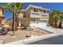 Exterior view of a tan home featuring a two car garage and xeriscaping at 576 Foster Springs Rd, Las Vegas, NV 89148