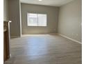 Bright living room with wood-look floors, fresh paint, and a large window that allows natural light at 6170 E Sahara Ave # 1012, Las Vegas, NV 89142