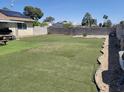 Expansive backyard with artificial turf, concrete block wall, and desert landscaping features at 6231 Santa Maria Ave, Las Vegas, NV 89108