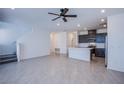 Spacious living area with gray tile flooring, recessed lighting, and an open-concept layout to the kitchen and staircase at 6288 Dolosonte St, Las Vegas, NV 89113